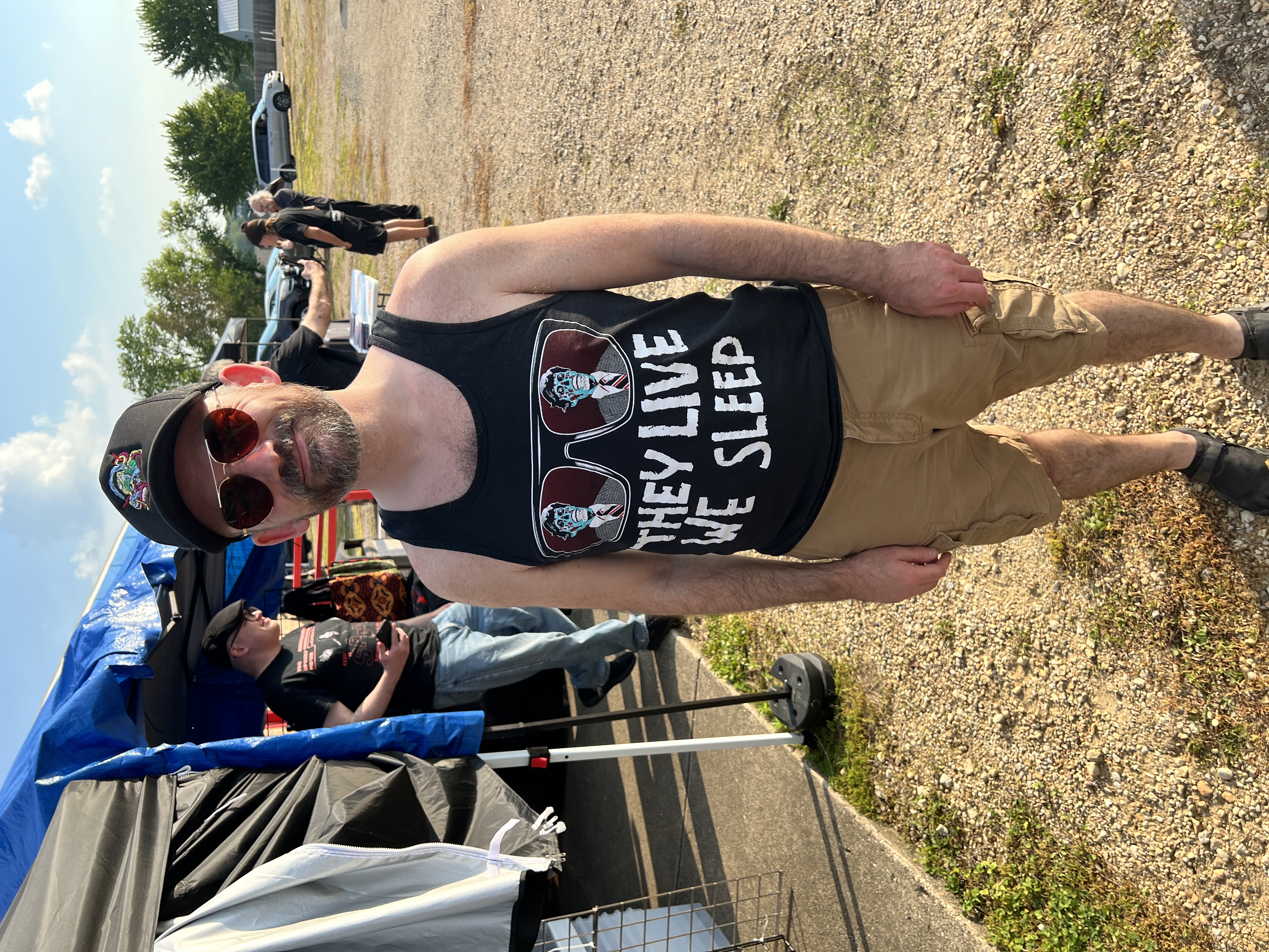Fan wearing They Live We Sleep tank top at convention